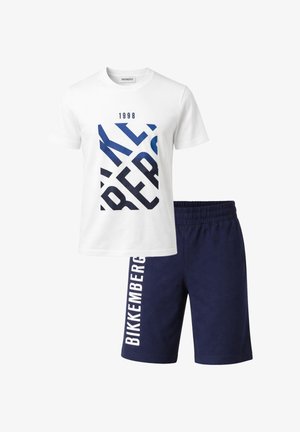 Maglietta bianca a maniche corte con grande scritta blu navy e pantaloncini blu navy con scritta verticale bianca "BIKKEMBERGS" su una gamba.