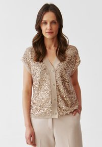 Short-sleeve, v-neck cardigan in light beige with scattered sequins and five-button front closure. Ribbed hem and sleeve edges.