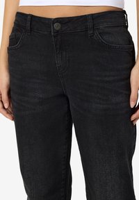 Zwarte denim jeans met een iets vervaagde textuur, vijf-pocket ontwerp, metalen knoopsluiting en gestructureerde tailleband.
