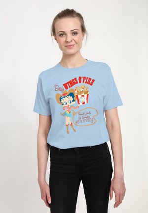 Lyseblå kortærmet t-shirt med et cartoon-graphic af en kvinde, rød tekst der siger "Betty's WINGS O' FIRE," og en illustration af en popcornboks.