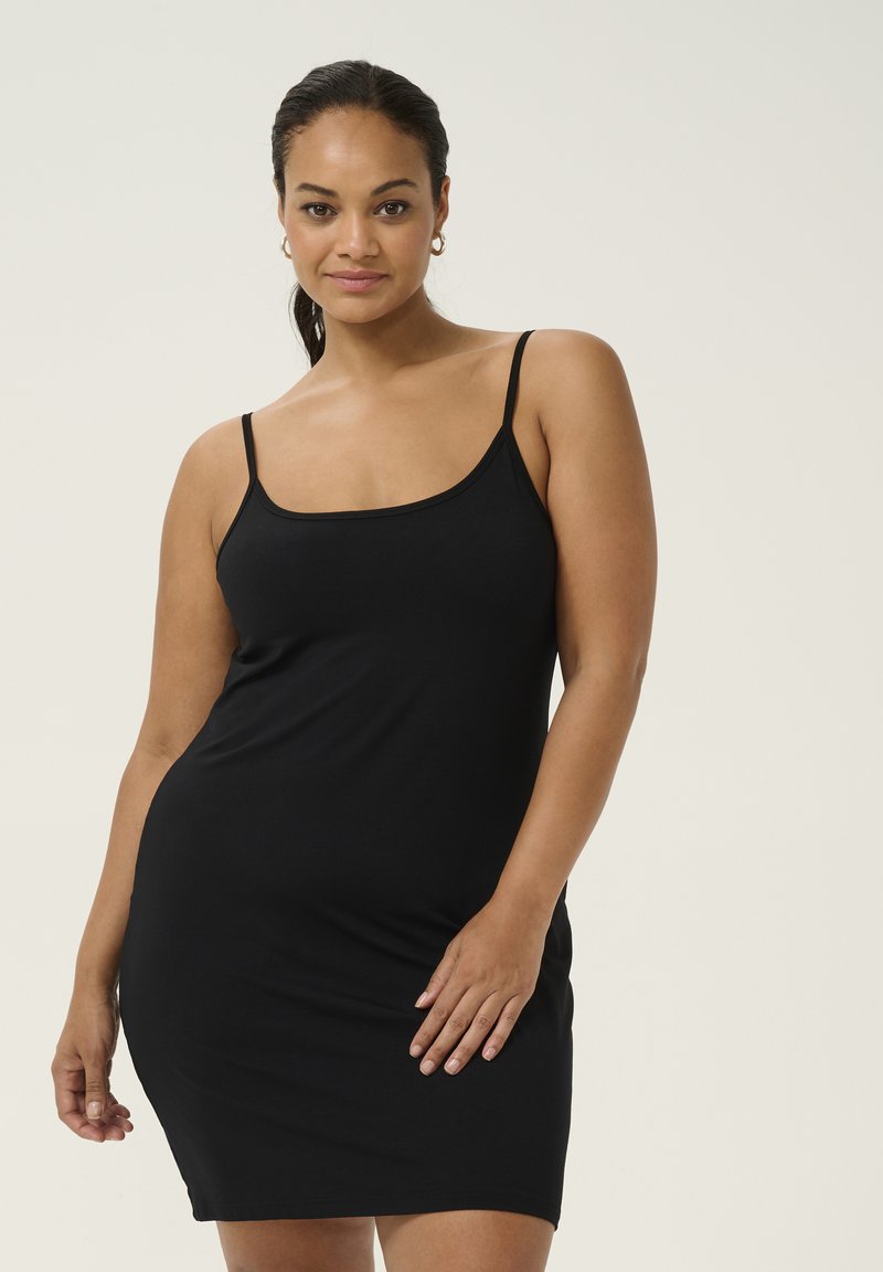Vestito nero senza maniche realizzato in tessuto liscio, design aderente, lunghezza al ginocchio con un semplice scollatura a girocollo e spalline regolabili.