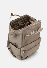 Beige rechthoekige rugzak met meerdere compartimenten, gevoerd intern vak, ritsvak aan de voorkant, zijzakken en een stoffen handvat aan de bovenkant.