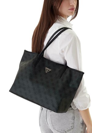 Sac cabas noir en matière texturée, avec une plaque logo et des anses en cuir. Forme rectangulaire avec un motif subtil.