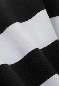 Černobílá pruhovaná tkanina s výraznými vodorovnými pruhy. Textura vypadá hladce a jemně, s pleteným povrchem.