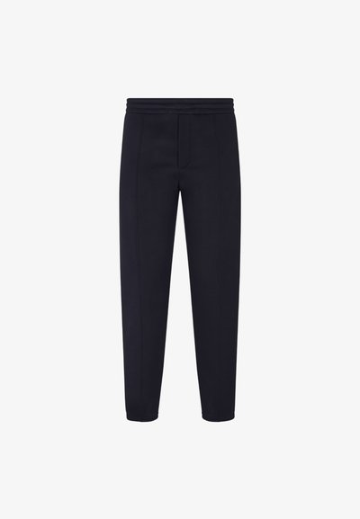 Marineblauwe tapered joggingbroek van een zachte stof met een brede elastische tailleband, voorzien van contrasterende stiksels en een voorzakdetails.