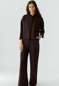 Brauner, verkürzter Hoodie mit Kordelzug und weit geschnittenen passenden Hosen. Glattes Material mit lässiger Passform und minimalen Nähten.