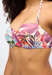 Bikini tops ar ziedu rakstu purpursarkanā, rozā un zilā tonī. Dizains ar noslēgtu priekšpusi un plānām regulējamām lencītēm.