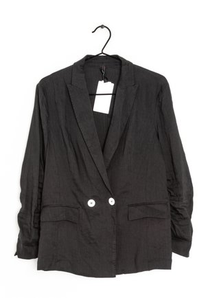 Schwarzer, doppelreihiger Blazer mit Notch-Revers, zwei weißen Knöpfen, aufgesetzten Fronttaschen, hängend an einem schwarzen Kleiderbügel mit weißem Etikett.