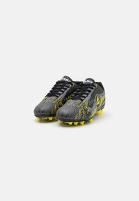 Crampons de football noirs et gris avec des accents jaunes ; présentent un dessus texturé, un laçage traditionnel et des crampons moulés pour une traction.