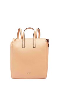 Sac à dos en cuir couleur pêche avec doubles poignées supérieures, design minimaliste et accent logo doré à l'avant. Fermeture éclair sur le côté.