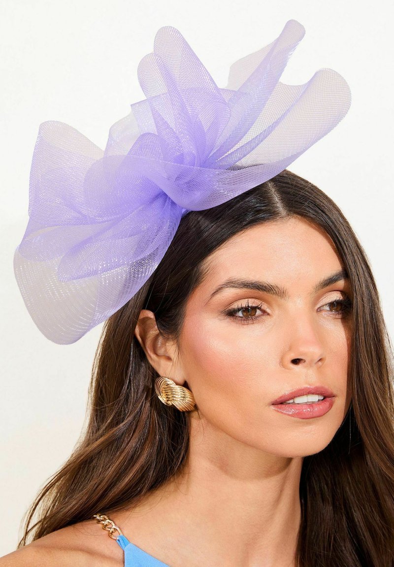 Fascinator in tulle lavanda con tessuto stratificato e fluente sopra una fascia per capelli; presenta un aspetto trasparente e testurizzato e un design morbido e voluminoso.