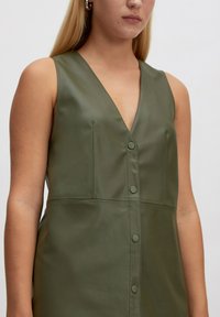 Grünes, künstliches Lederkleid ohne Ärmel mit tiefem V-Ausschnitt und Knopfleiste, das eine glatte Textur und ein minimalistisches Design aufweist.