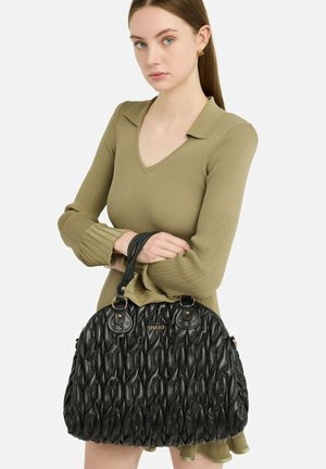 Sac à main en cuir noir avec texture tissée et accents en métal doré. Comprend deux poignées et une forme arrondie. Logo de la marque affiché de manière bien visible.