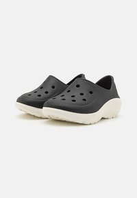 Svarta formgjutna träskor med ventilationshål, vita texturerade sulor, ergonomisk design och slip-on stil för enkel på och av.
