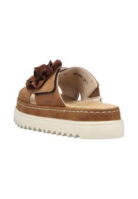 Brown leather sandal with a textured flower accent, cushioned interior, and a thick white sole featuring a zigzag pattern.