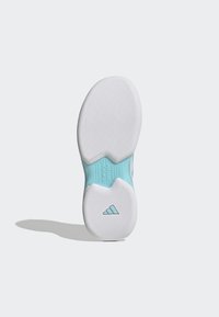 White sneaker outsole with textured surface, light blue accents, and a triangular logo. Features a distinctive Torsion System design.