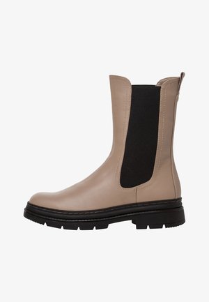 Beige leather ankle boot with black elastic side panels, flat sole, round toe, and pull tab at the back for easy wear.