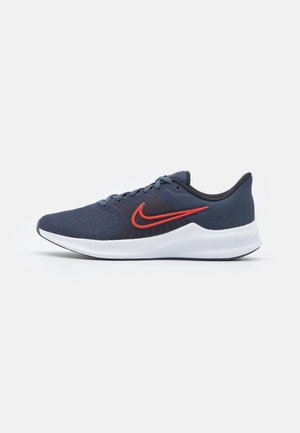Dark blue Nike running shoe with red logo, white sole, and mesh upper, viewed from the right side on a plain white background.