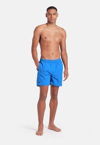 Blå badshorts av lätt material med resår i midjan och sidofickor. Har en liten logga på vänster lår.