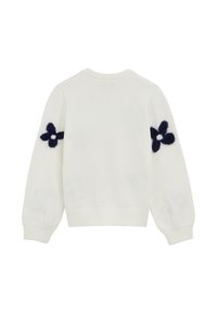 Pulover alb cu maneci lungi, cu petice de flori negre pufoase pe ambele coate, cu manșete, tiv și guler cu răsucire, prezentat din spate.