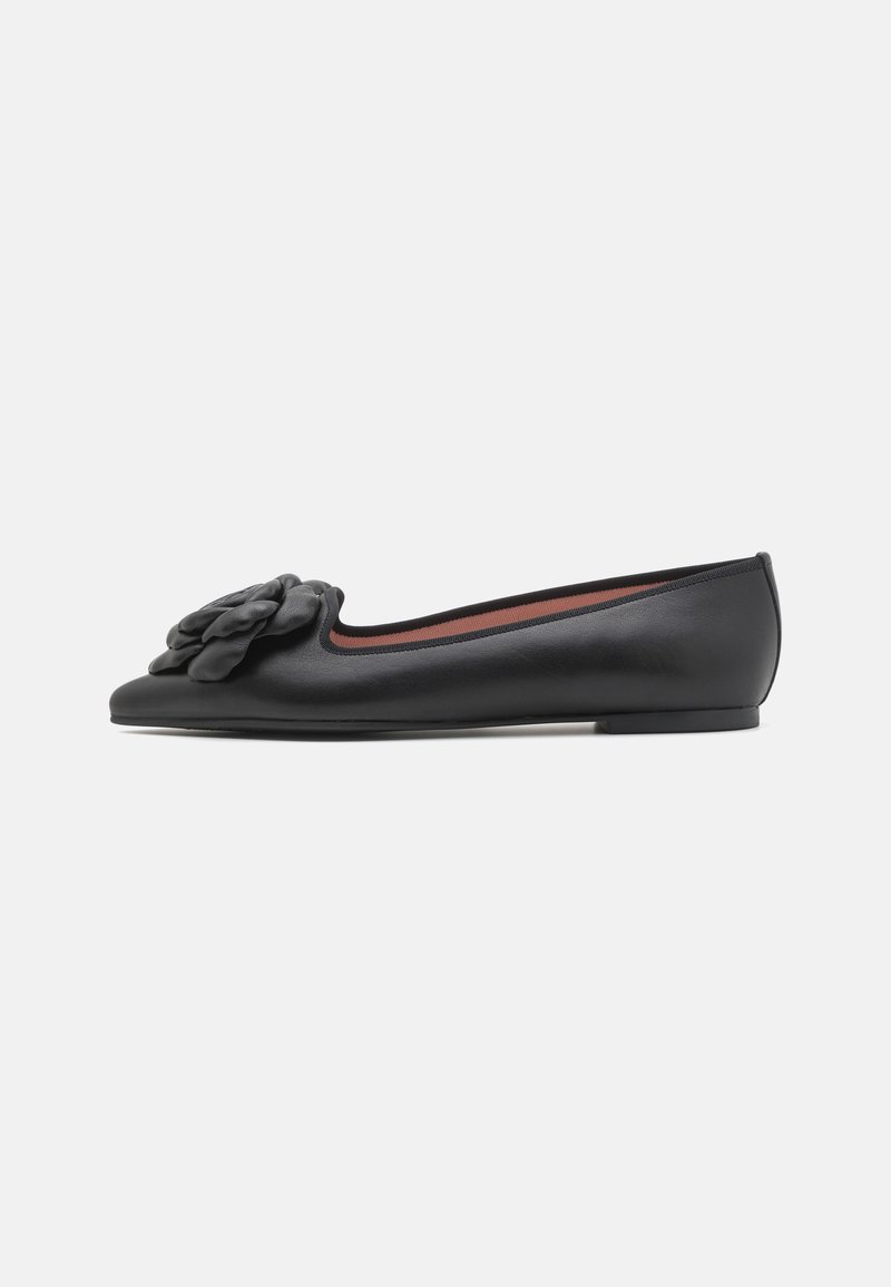 Bailarinas de cuero negro con punta redonda, que presentan un acento floral texturizado en el empeine y un diseño minimalista. Suela plana.