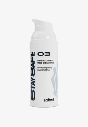 Biała butelka z pompką z czarnym napisem. Etykieta mówi "BEZPIECZNY 03" i zawiera nazwę produktu w języku niemieckim. Na etykiecie znajduje się grafika w miękkim niebieskim falistym wzorze.