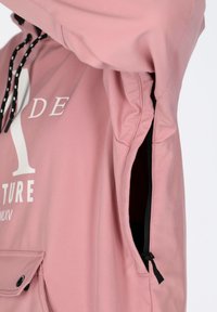 Lyserød hættejakke med sorte snore og lynlås i siden. Har en lomme foran med trykknaplukning og hvidt trykt tekst på brystet.