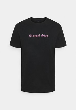 Camiseta de algodón negra con mangas cortas que presenta el texto "Estado Tranquilo" en una fuente estilizada rosa en el pecho. Ajuste regular.