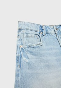 Jean en denim bleu clair délavé avec des détails usés, conception à cinq poches et éléments en métal argenté sur le bouton et la fermeture éclair.