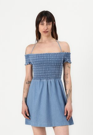 Denim obleka brez naramnic z nabrano corsetno zgornjim delom, kratkimi rokavi in razširjenim krilom v svetlo modri barvi z gladko teksturo.
