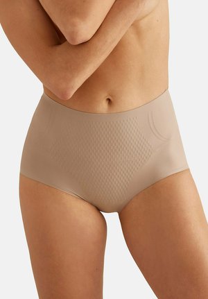 Culotte gainante beige taille haute sans coutures sur un ventre nu, avec un panneau avant texturé et des côtés lisses, sur un fond uni.