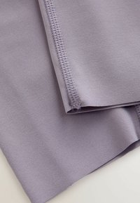 Lyse lilla, glat stof med en let glans; har flade sømme langs kanten og en blød, elastisk tekstur.