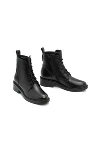 Botas de tobillo de cuero negro con cierre de cordones y cremallera lateral, parte superior texturizada, punta redondeada y tacón bajo.