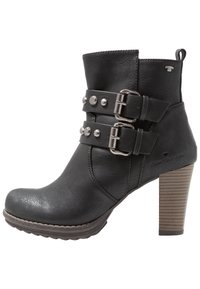 Bottine en similicuir noir avec deux brides à boucles, clous argentés et un talon épais en bois présentant des rainures horizontales.