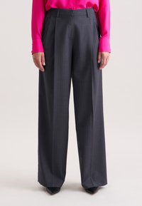 Grijs gestreepte wijde broek met een geplooide voorkant, met een op maat gemaakte pasvorm en een gladde stofstructuur. Gecombineerd met een felroze blouse.