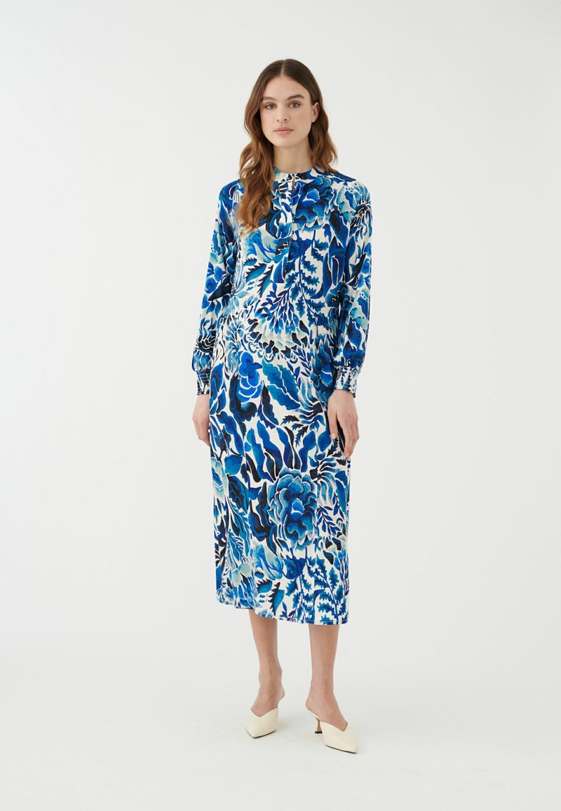 Blumen-Midi-Kleid in Blautönen, mit langen Ärmeln, hohem Kragen, das eine Vielzahl von Blatt- und Blütenmustern zeigt. Glatter Stoff und knöchellang.