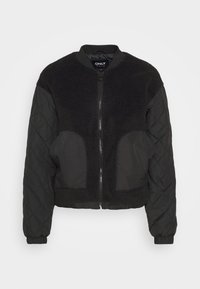 Blouson aviateur noir avec un devant en polaire douce et texturée et des manches en tissu matelassé. Fermeture éclair, ourlet et poignets élastiqués.