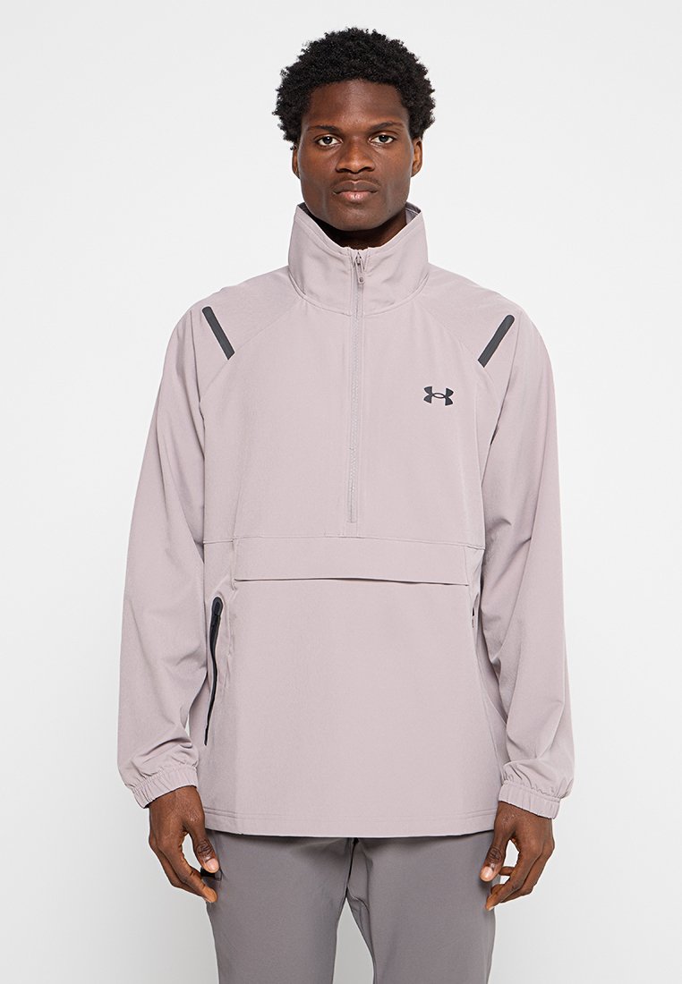 Leicht lila Pulloverjacke mit hohem Kragen, halbem Reißverschluss und schwarzen Akzenten an den Schultern. Hergestellt aus leichtem, strukturiertem Stoff.