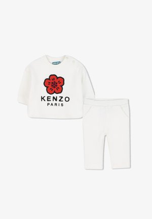 Ensemble en coton blanc comprenant un haut à manches longues avec une broderie de fleurs rouges et le texte « KENZO PARIS », associé à un pantalon blanc assorti.