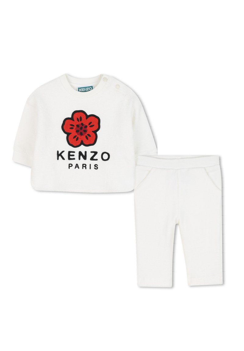 Ensemble en coton blanc comprenant un haut à manches longues avec une broderie de fleurs rouges et le texte « KENZO PARIS », associé à un pantalon blanc assorti.