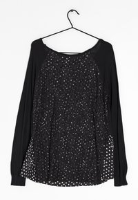 Schwarzes Langarmoberteil mit einer strukturierten Spitzenvorderseite und silbernen Akzenten sowie einem gepunkteten Rückenteil. Weicher Stoff mit lässiger Passform.