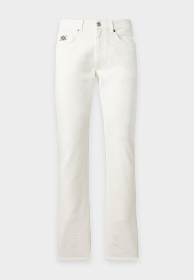 Jean blanc à jambe droite avec bouton et fermeture éclair devant, passants de ceinture et poches, présenté sur un fond gris clair uni.