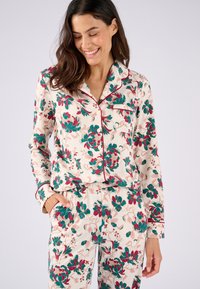 Set da pigiama floreale con uno sfondo crema e fiori verdi, rosa e rossi. La parte superiore ha maniche lunghe e bordi in contrasto; i pantaloni hanno una vita elasticizzata.
