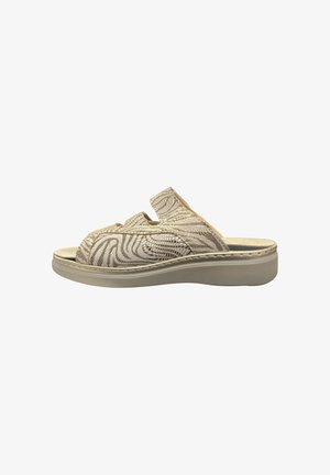 Beige slip-on sandal with cushioned sole and textured wavy pattern, open toe, and backless design for casual wear.