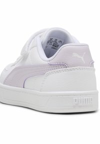 Baskets blanches avec une bande accent légère couleur mauve, fabriquées en matériau synthétique lisse, dotées d'une semelle texturée et d'une marque imprimée sur le talon.