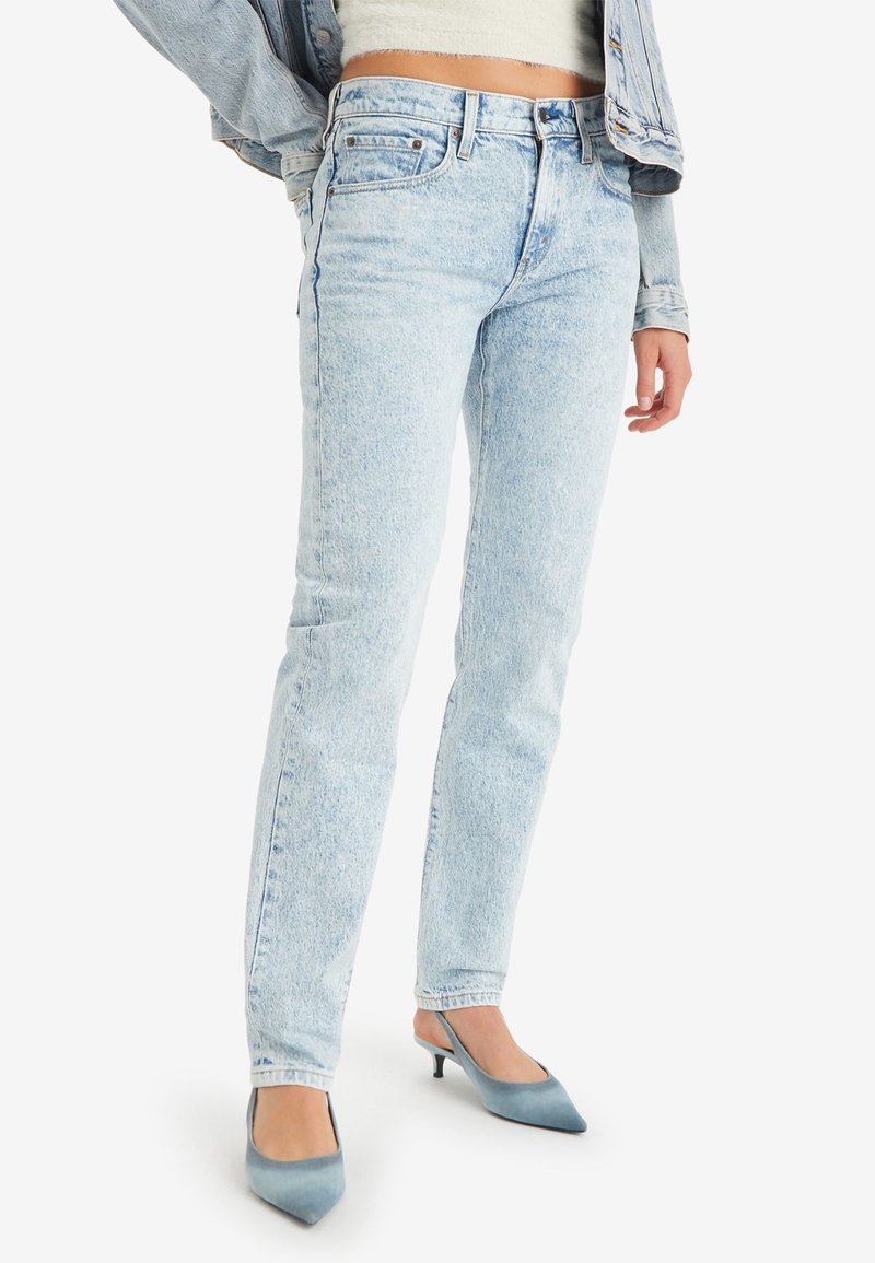 Jean en denim bleu clair avec une coupe droite, dotés d'une taille haute, d'un léger dégradé et d'un style classique à cinq poches.