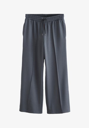 Sive široke trenirka hlače s elastičnim pojasom, detaljem s vezicom i džepovima. Izrađene od glatkog, laganog materijala.