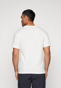 Weißes T-Shirt mit kurzen Ärmeln aus Baumwolle, mit rundem Halsausschnitt und einem schlichten Design, ohne Muster oder Akzente auf der Rückseite.