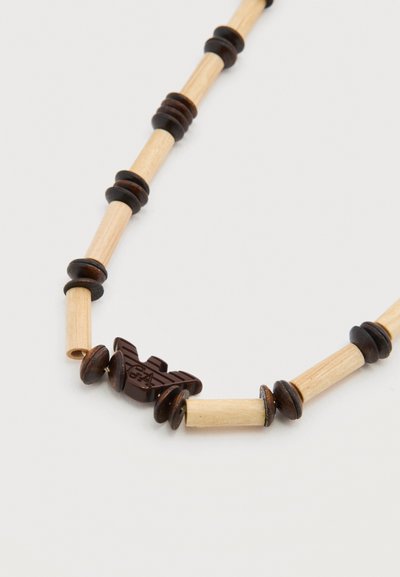 Κολιέ με εναλλασσόμενους κυλινδρικούς χάντρες από ανοιχτόχρωμο ξύλο και σκούρους ξύλινους δίσκους, με μια σκούρα χάντρα σε σχήμα πουλιού που φέρει χαραγμένα τα γράμματα "G&A".