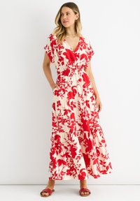 Floral maxi dress with a deep V-neck, red and cream colors, cinched waist, short sleeves, and tiered skirt featuring large red flower patterns.